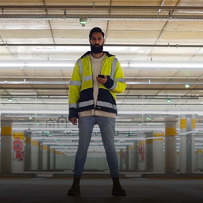 Das Bild zeigt einen Servicemitarbeiter in einem Parkhaus.