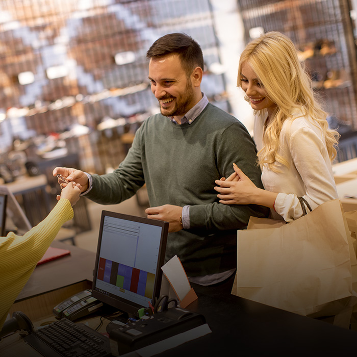 The picture shows a woman and a man at a checkout counter.